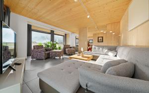ein Wohnzimmer mit einem Sofa und einem Tisch in der Unterkunft Aparthotel Zell am See (Contactless Check-In) in Zell am See