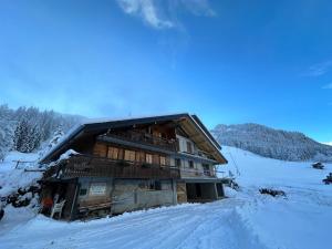 uma cabana de madeira na neve numa montanha em L'Étoile du Linga em Châtel