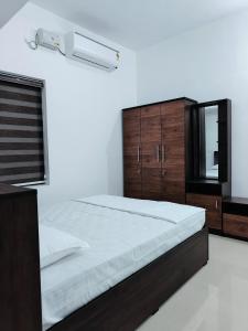 a bedroom with a large bed and a mirror at Munroe La Casa in Kollam