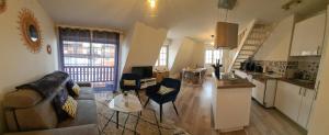 a living room with a couch and a kitchen at Duplex au cœur de Deauville avec vue imprenable et parking privé in Deauville +7 photos