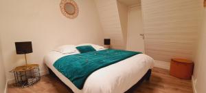 a bedroom with a large bed with a green blanket at Duplex au cœur de Deauville avec vue imprenable et parking privé in Deauville