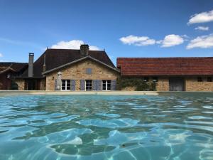 a pool of water in front of a building at Le Pompon D'Or in Saint-Pompont