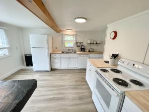 uma cozinha com electrodomésticos brancos e um frigorífico branco em Beachfront 4 BR Spacious House! [Coastal Haven] em Tremont