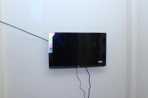 telewizor z płaskim ekranem wiszący na białej ścianie w obiekcie Archu Agam w mieście Kotagala