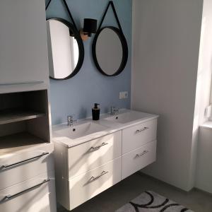 a bathroom with two sinks and a mirror on the wall at neutal-ferienapartments in Neutal