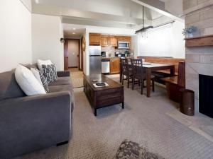 a living room and kitchen with a couch and a table at Slope-Side Serenity Ski-In Ski-Out Gem with Pool in Park City