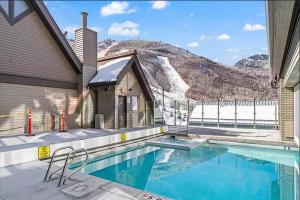 a swimming pool with a mountain in the background at Slope-Side Serenity Ski-In Ski-Out Gem with Pool in Park City