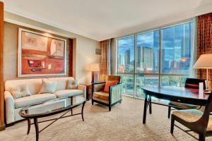 a living room with a couch and a table at Strip View Suites - No Resort Fee ! in Las Vegas