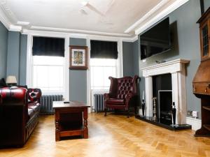 a living room with a couch and a chair and a fireplace at Churchill Brighton in Brighton & Hove