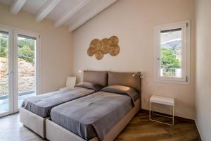 a bedroom with a large bed and two windows at Villa Margidore in Lacona