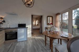 a living room with a table and a kitchen at CHARME AU FIL DE L'EAU in Vendières