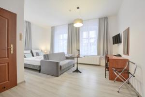 ein Wohnzimmer mit einem Bett, einem Sofa und einem Tisch in der Unterkunft Hotel Kryształ in Świeradów-Zdrój