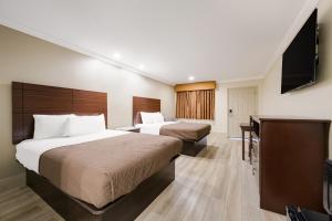 een hotelkamer met 2 bedden en een flatscreen-tv bij Americas Best Value Inn I-45 / Loop 610 in Houston