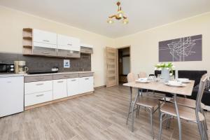 a kitchen and dining room with a table and chairs at Peaceful Apartment Wrzosowo Bay with Parking by Renters in Dziwnówek