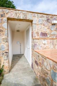 a stone wall with a garage with a door at Villa Margidore in Lacona