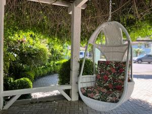 Un columpio blanco con un asiento con flores. en San Clemente Residence, en Gramado