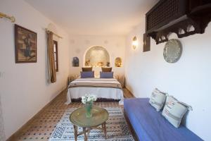 a bedroom with two beds and a table in a room at Riad Fes Kettani in Fez