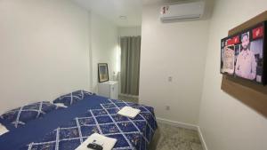 a bedroom with a bed with a tv on the wall at Terra das Palmeiras in Barreirinhas