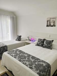 1 dormitorio con 2 camas y ventana en San Clemente Residence, en Gramado