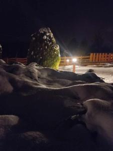 Una gran roca en la nieve por la noche en Dom Pod Gaikiem, en Łękawica
