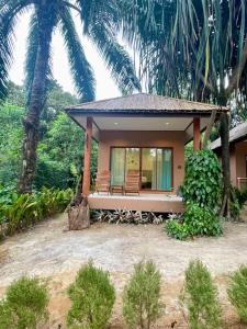 ein Haus mit Palmen davor in der Unterkunft Sunny Cove Beach Resort Koh Phayam in Ranong