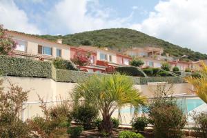 Mini villa Hameaux des Sanguinaires AJACCIO في أجاكسيو: اطلالة على مبنى فيه جبل في الخلفية