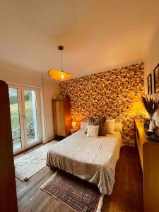 een slaapkamer met een bed en een stenen muur bij La Maison Grise - vacances familiales in Le Tholy