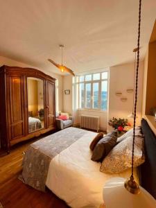 een slaapkamer met een groot bed en een grote spiegel bij La Maison Grise - vacances familiales in Le Tholy