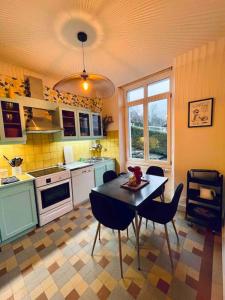 een keuken met een tafel en stoelen. bij La Maison Grise - vacances familiales in Le Tholy