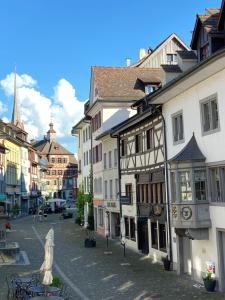 a street in a town with buildings and a church at Understadt 14 guesthouse in Stein am Rhein