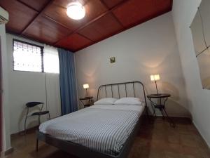 - une chambre avec un lit, 2 tables et 2 lampes dans l'établissement Villa Gascue Guest Apartments, à Saint-Domingue