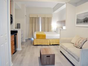 um quarto de hotel com uma cama e um sofá em The Point Hotel & Suites Universal em Orlando