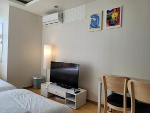 sypialnia z łóżkiem, telewizorem i stołem w obiekcie Gangnam Coex w Seulu