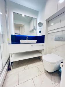 a white bathroom with a sink and a toilet at Elite Class Sea View ApartHotel in Orbi city in Batumi