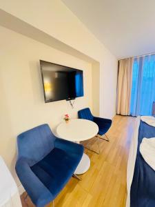 um quarto com uma mesa e duas cadeiras e uma televisão em Elite Class Sea View ApartHotel in Orbi city em Batumi