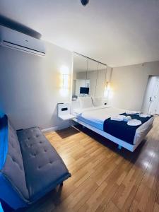 a bedroom with a bed and a chair and a mirror at Elite Class Sea View ApartHotel in Orbi city in Batumi