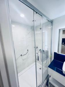 um chuveiro com uma porta de vidro na casa de banho em Elite Class Sea View ApartHotel in Orbi city em Batumi