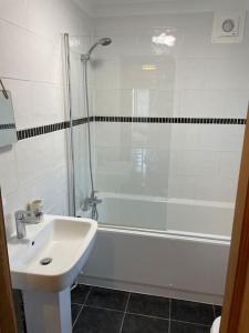 La salle de bains blanche est pourvue d'un lavabo et d'une douche. dans l'établissement Wonderland!, à Lincolnshire