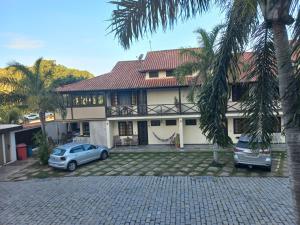 una casa con due macchine parcheggiate di fronte di Casa Agradável no Paraiso de Arraial do Cabo ad Arraial do Cabo