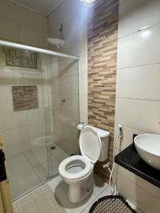 ein Bad mit einer Dusche, einem WC und einem Waschbecken in der Unterkunft Recanto da lua in Prado
