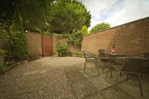 a patio with a table and chairs next to a brick wall at Grayz Townhouse - Free onsite parking for 2 cars in Lincoln