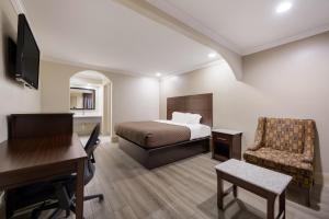 een hotelkamer met een bed, een bureau en een stoel bij Americas Best Value Inn I-45 / Loop 610 in Houston