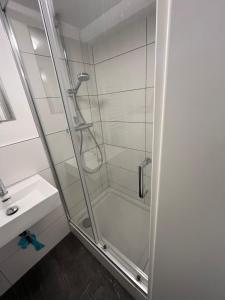 una ducha con una puerta de cristal junto a un lavabo en Sahra 1Zi. Wohnung Arheiligen, en Darmstadt