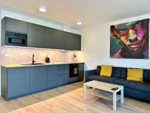 a living room with a blue couch and a kitchen at Vivien Modern City in Brno