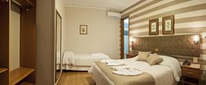 a hotel room with a bed with towels on it at Bellagio Mini Resort - no coração de Gramado in Gramado