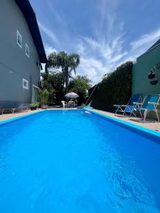 uma grande piscina azul ao lado de um edifício em Casa da Sandra em Florianópolis