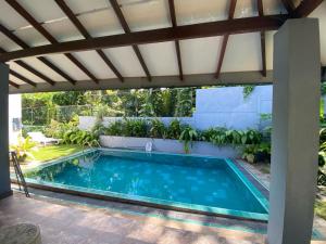 - une piscine sous une pergola à côté d'une maison dans l'établissement Lady Nelly villa Hikkaduwa, à Hikkaduwa