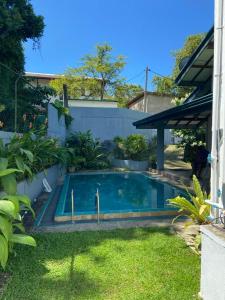 une piscine dans l'arrière-cour d'une maison dans l'établissement Lady Nelly villa Hikkaduwa, à Hikkaduwa