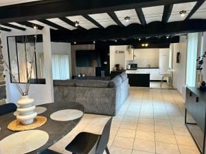 a living room with a couch and a table and a kitchen at L AUBERGE DE l Entre Potes Scandinavia in Ath