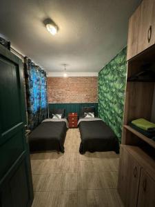 a room with two beds and green walls at Stay in Poznan Tropical in Poznań